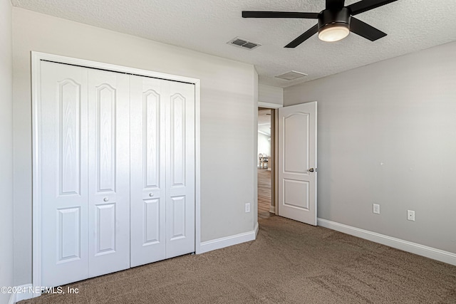 unfurnished bedroom with carpet flooring, a closet, ceiling fan, and a textured ceiling