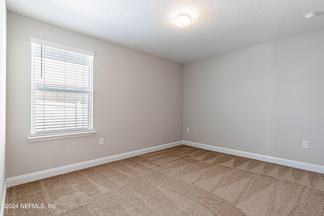 unfurnished room with carpet flooring and a textured ceiling