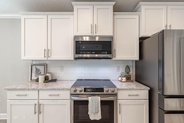 kitchen with appliances with stainless steel finishes, tasteful backsplash, white cabinetry, and light stone countertops