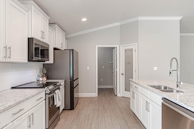 kitchen featuring white cabinets, light hardwood / wood-style floors, crown molding, and stainless steel appliances