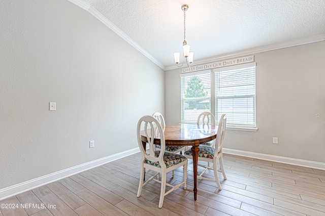 dining space featuring ornamental molding, light hardwood / wood-style flooring, a textured ceiling, and a notable chandelier