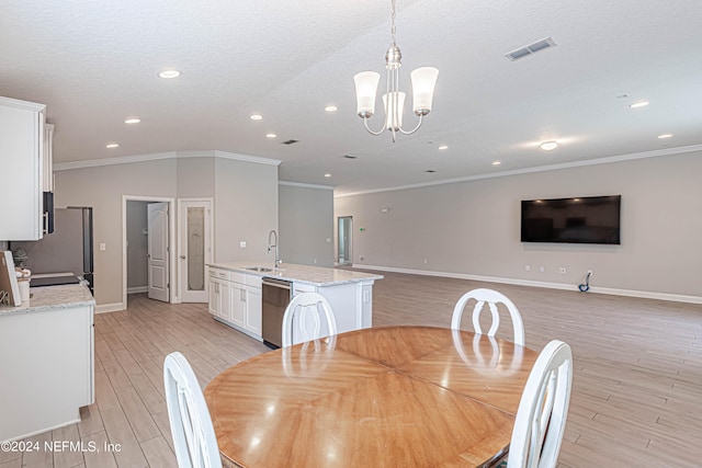 dining area featuring ornamental molding, light hardwood / wood-style flooring, a notable chandelier, and sink