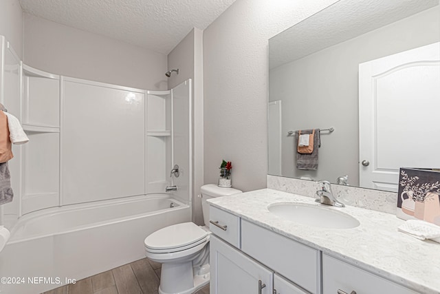 full bathroom with bathtub / shower combination, a textured ceiling, vanity, and toilet