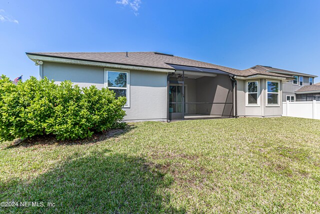 rear view of property featuring a yard