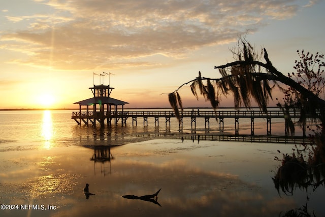 view of dock with a gazebo, a view of the beach, and a water view