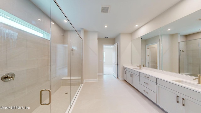 bathroom with double vanity, a stall shower, visible vents, and a sink