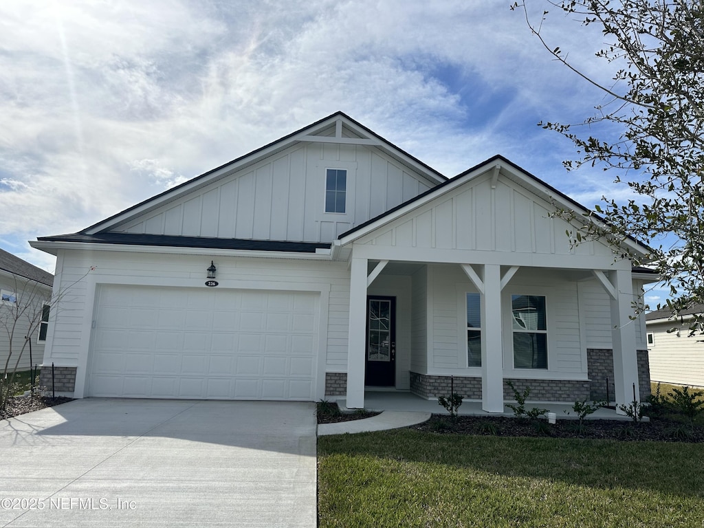 226 Palomar Dr, Saint Johns, FL 32259 - view of front of property with concrete driveway, board and batten siding, a front yard, covered porch, and a garage