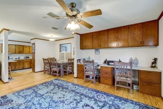 home office with light hardwood / wood-style flooring and ceiling fan