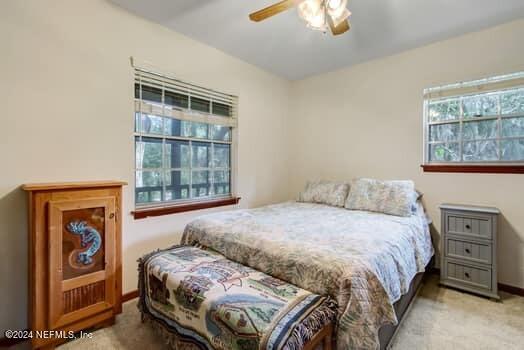 bedroom featuring light carpet and ceiling fan