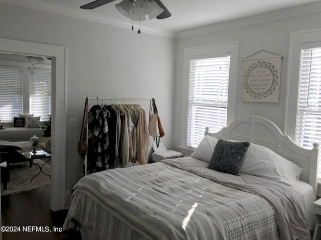 bedroom featuring ceiling fan, multiple windows, crown molding, and hardwood / wood-style flooring