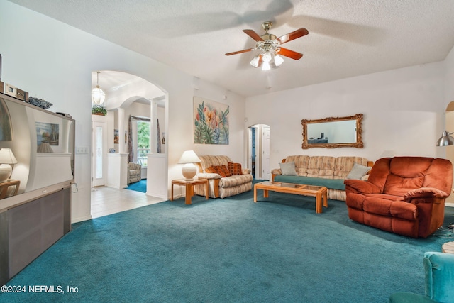 living room with ceiling fan, carpet flooring, and a textured ceiling