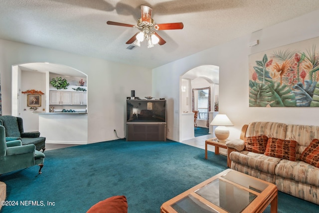 living room featuring a textured ceiling, ceiling fan, and carpet