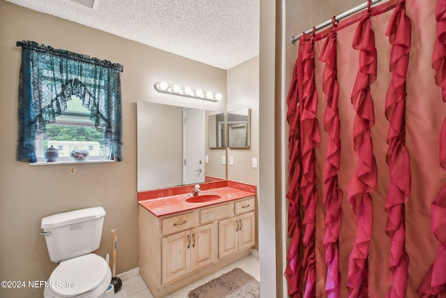 bathroom featuring toilet, tile floors, a textured ceiling, and large vanity