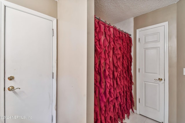 bathroom with tile flooring and a textured ceiling