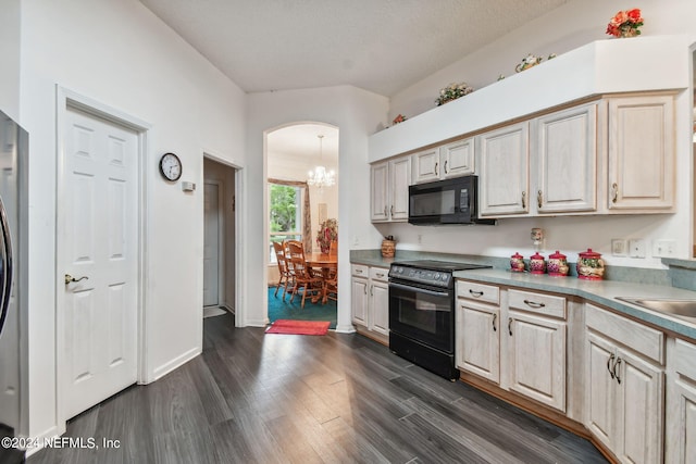 kitchen featuring dark hardwood / wood-style flooring, an inviting chandelier, and black appliances