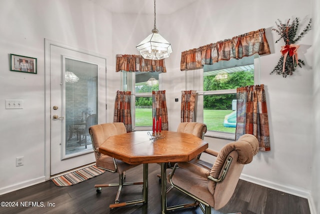 dining room with wood-type flooring, plenty of natural light, and a towering ceiling