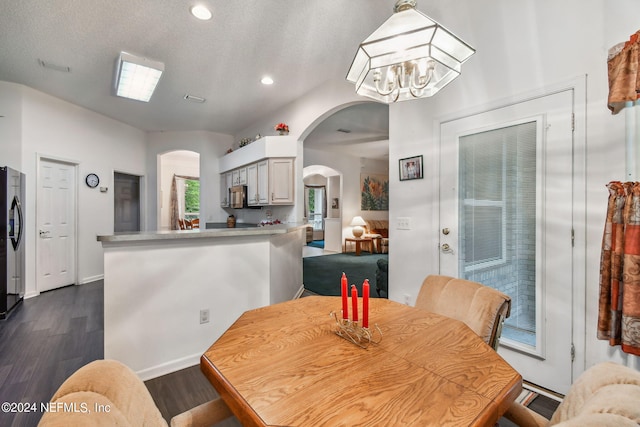 dining room with a textured ceiling, dark hardwood / wood-style floors, and a notable chandelier