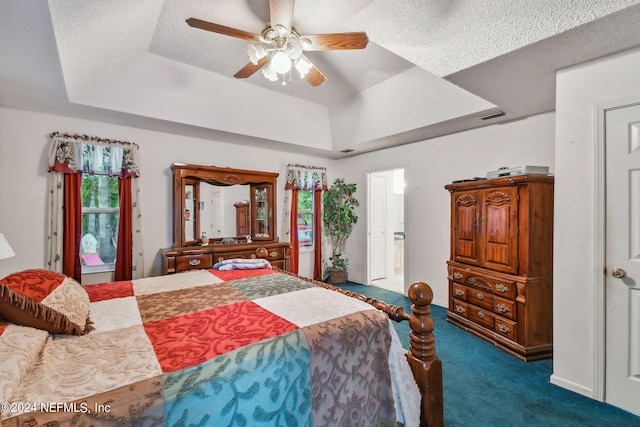 bedroom with carpet, ceiling fan, a tray ceiling, and a textured ceiling