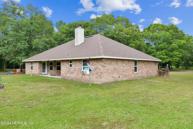 rear view of property featuring a lawn