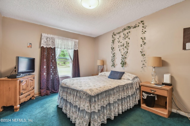 bedroom featuring dark colored carpet and a textured ceiling