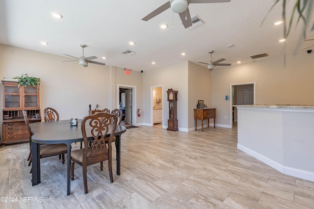 dining room featuring a textured ceiling, ceiling fan, and light tile floors