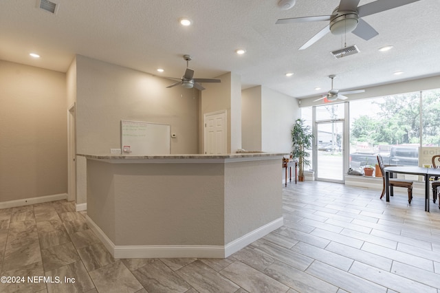 kitchen with a textured ceiling, ceiling fan, and light tile floors