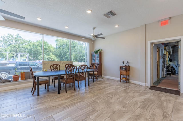 dining area with a textured ceiling, ceiling fan, and light tile floors