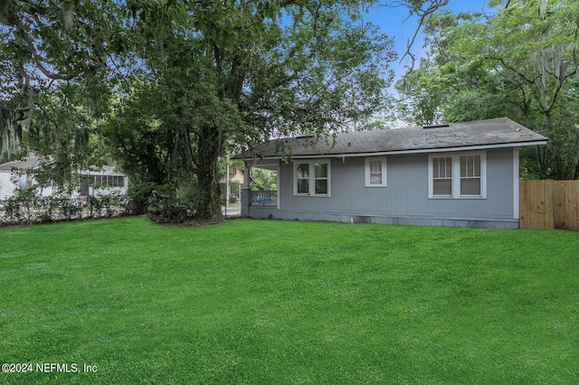 rear view of property featuring a lawn