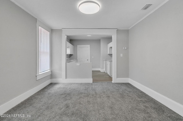 spare room featuring crown molding and carpet floors