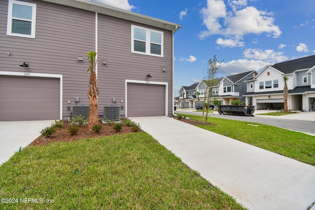 view of front of property featuring central air condition unit, a front yard, and a garage