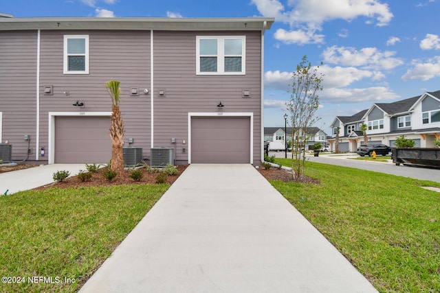 view of front facade featuring central AC, a garage, and a front lawn