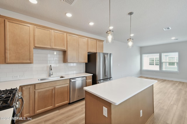 kitchen with a center island, sink, light wood-type flooring, and stainless steel appliances