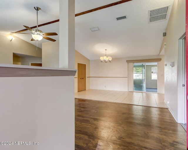 unfurnished room with ceiling fan with notable chandelier, wood-type flooring, and vaulted ceiling