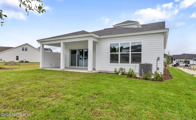 rear view of house featuring a lawn, central air condition unit, and a patio