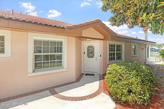 view of exterior entry with a patio area