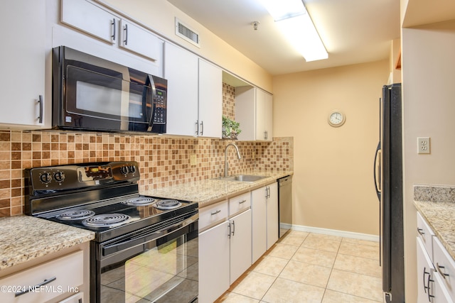 kitchen featuring sink, backsplash, light tile floors, and black appliances