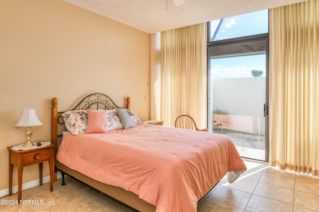 tiled bedroom with floor to ceiling windows, access to exterior, and a textured ceiling