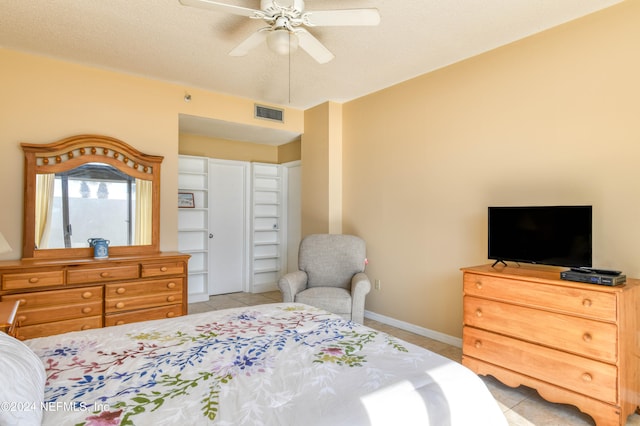 bedroom featuring a textured ceiling, ceiling fan, and light tile flooring