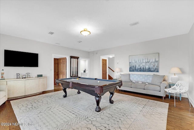 rec room with pool table, a textured ceiling, and hardwood / wood-style flooring