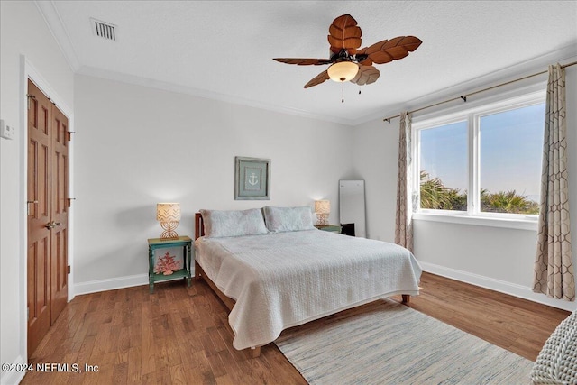 bedroom featuring ceiling fan, dark hardwood / wood-style floors, and ornamental molding