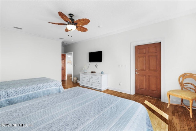 bedroom with ceiling fan, dark hardwood / wood-style flooring, and ornamental molding