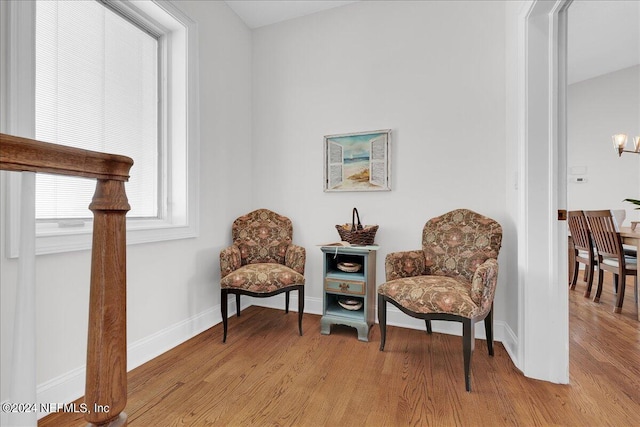 living area featuring light hardwood / wood-style flooring and a notable chandelier