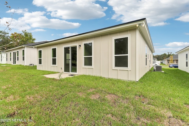 rear view of property with a yard and central air condition unit