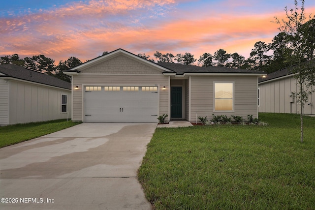 view of front of home with a garage and a yard