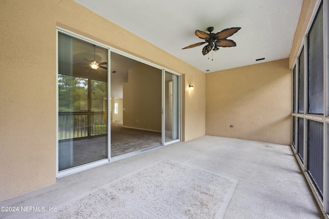 unfurnished sunroom featuring ceiling fan