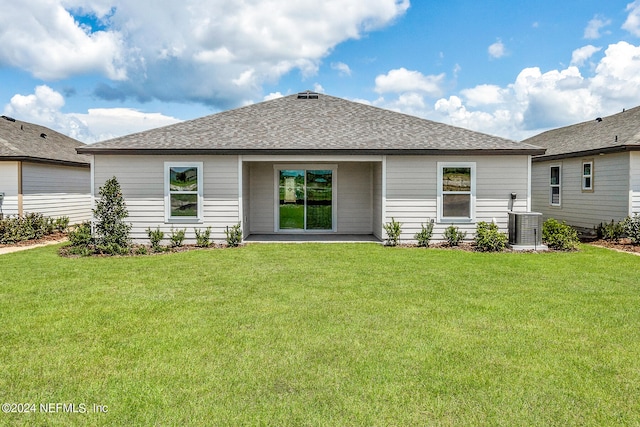 rear view of property featuring a yard and central air condition unit