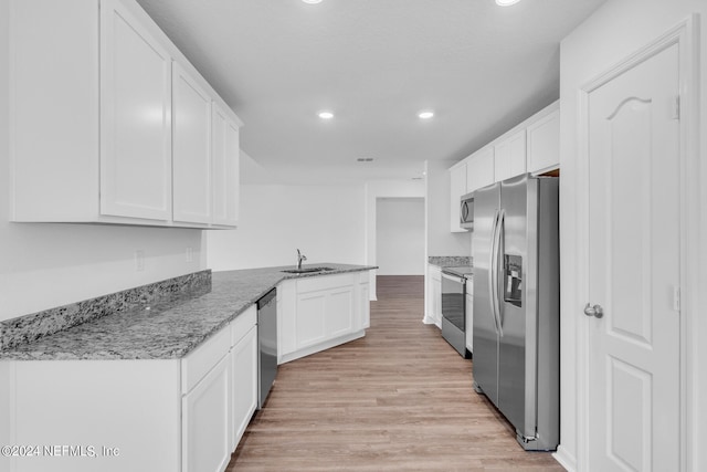 kitchen with white cabinets, light hardwood / wood-style floors, stainless steel appliances, and stone counters