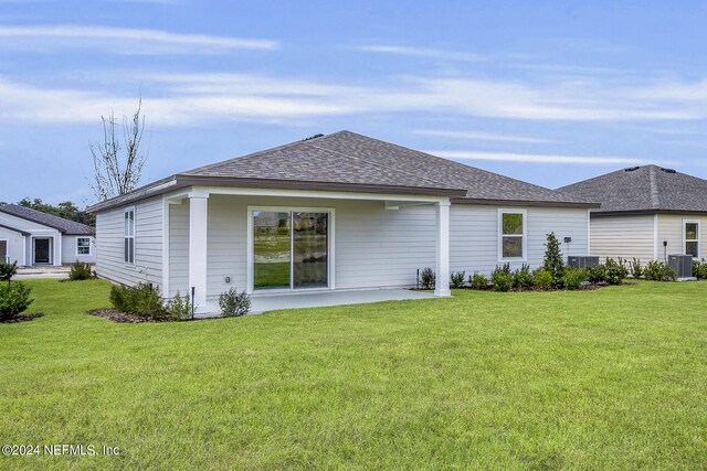 back of property featuring a patio, a yard, and central AC