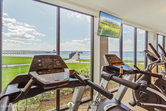 exercise room with a water view