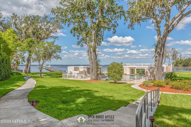 view of home's community featuring a swimming pool, a water view, and a yard